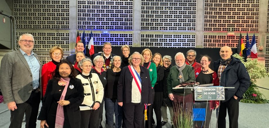 Eine Gruppe von erwachsenen Männern und Frauen, die sich zum Gruppenfoto aufgestellt haben.