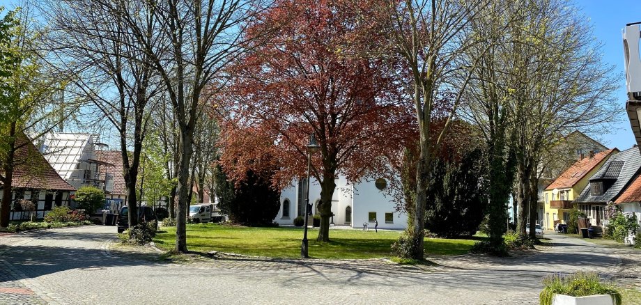 Eine in eine Art Parklandschaft eingebettete weiße Kirche. 