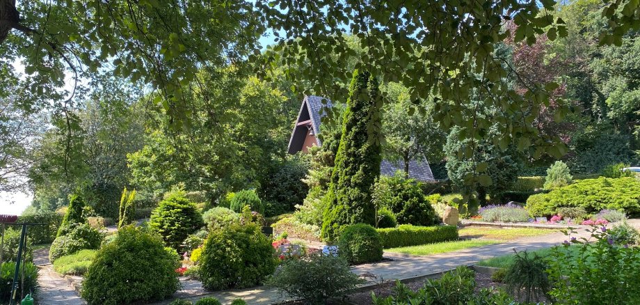 Ein am Hang gelegener Friedhof auf dem viele Gräber und im Hintergrund eine Kapelle zu sehen sind.