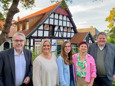 Die drei Standesbeamtinnen sowie zwei Standesbeamte der Gemeinde Stemwede, die vor einem historischen Fachwerkhaus stehen. 