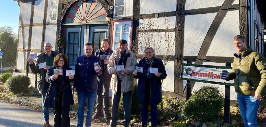 Eine Gruppe von Menschen steht vor einem historischen Fachwerkhaus.