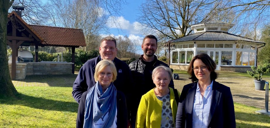 Gruppenfoto in einer parkähnlichen Fläche: drei Frauen stehen im Vordergrund, zwei Männer hinter ihnen. 