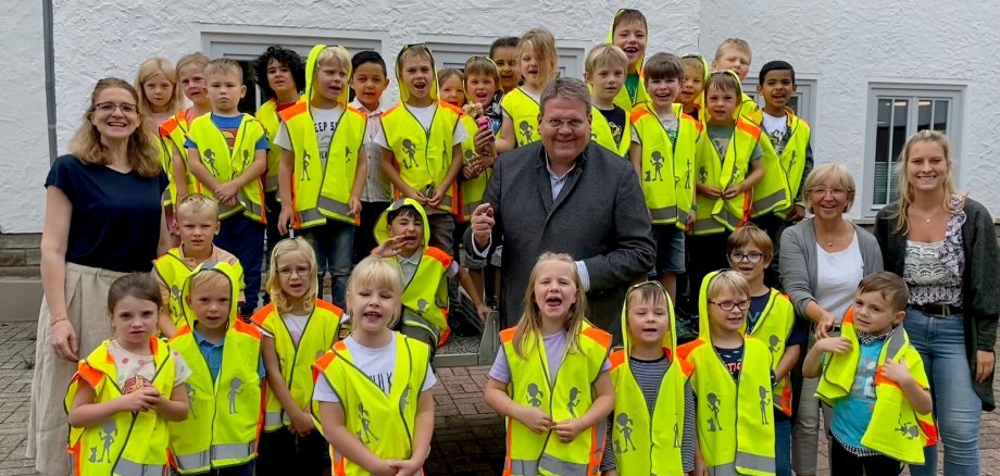 Gruppenfoto mit vielen Kindern in knallgelben Warnwesten. 