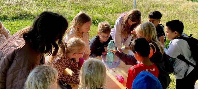 Einige Kinder machen Experimente mit Wasser.