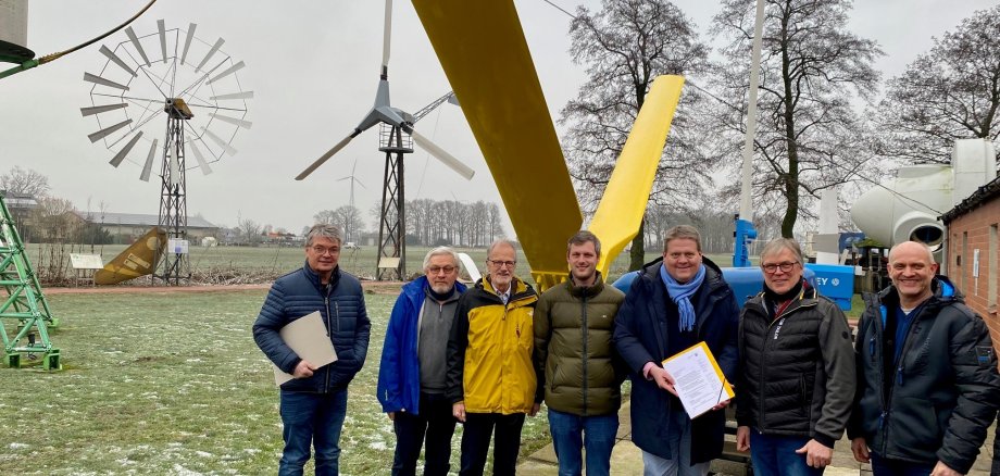 Gruppenfoto mit sieben Männern auf dem Außengeländes eines Mühlenmuseums.